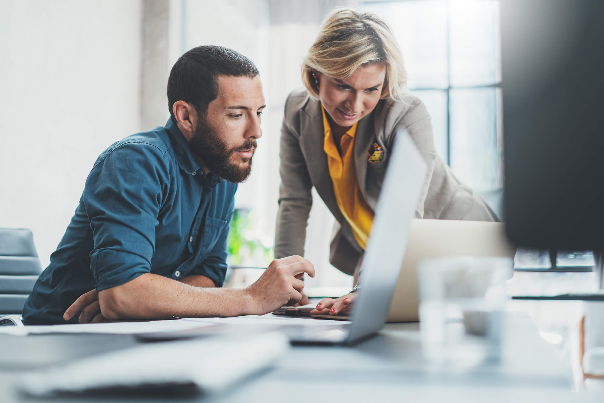 Two members of an HR team analyzing performance data to standardize their promotion decision-making process and prevent promotion bias