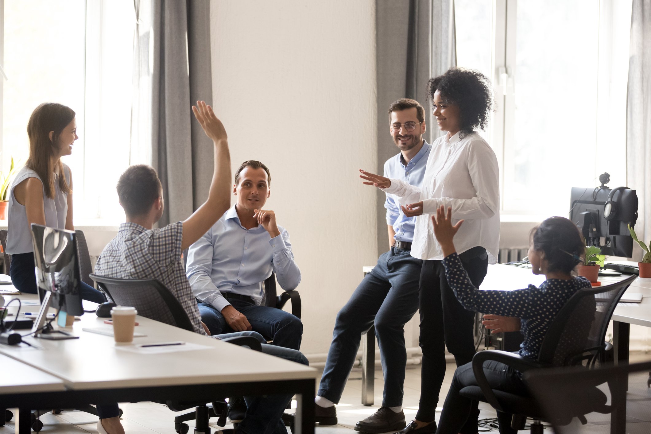 Three men and three women gather in an office for a people ops team meeting to clearly define performance, potential, promotability, and readiness in regards to the talent review process.