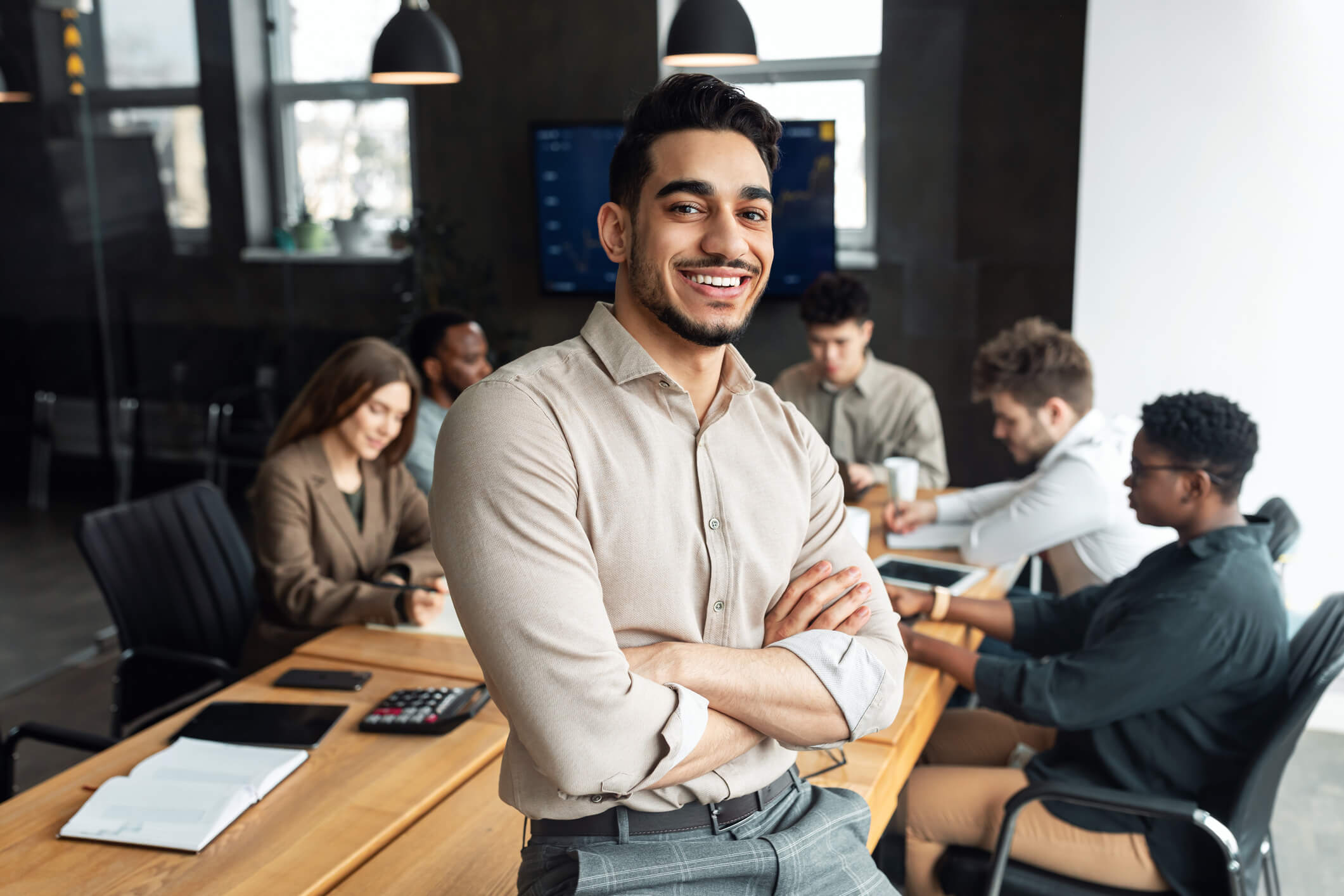 Man from people ops team leaning against conference desk